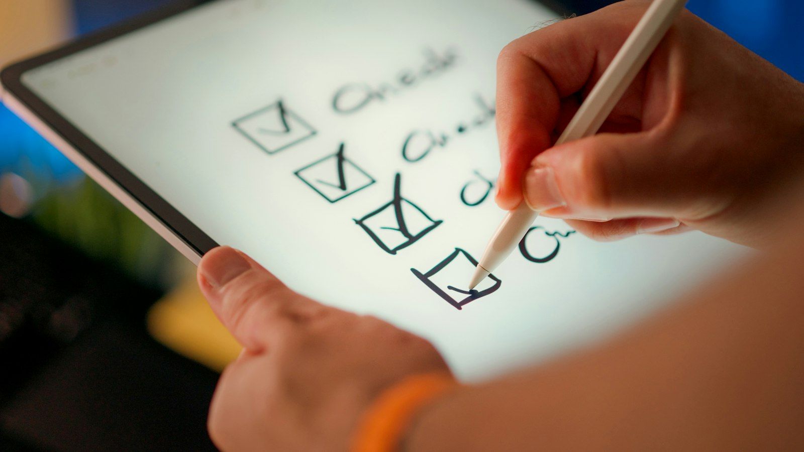 A hand ticking items off a checklist on a tablet screen
